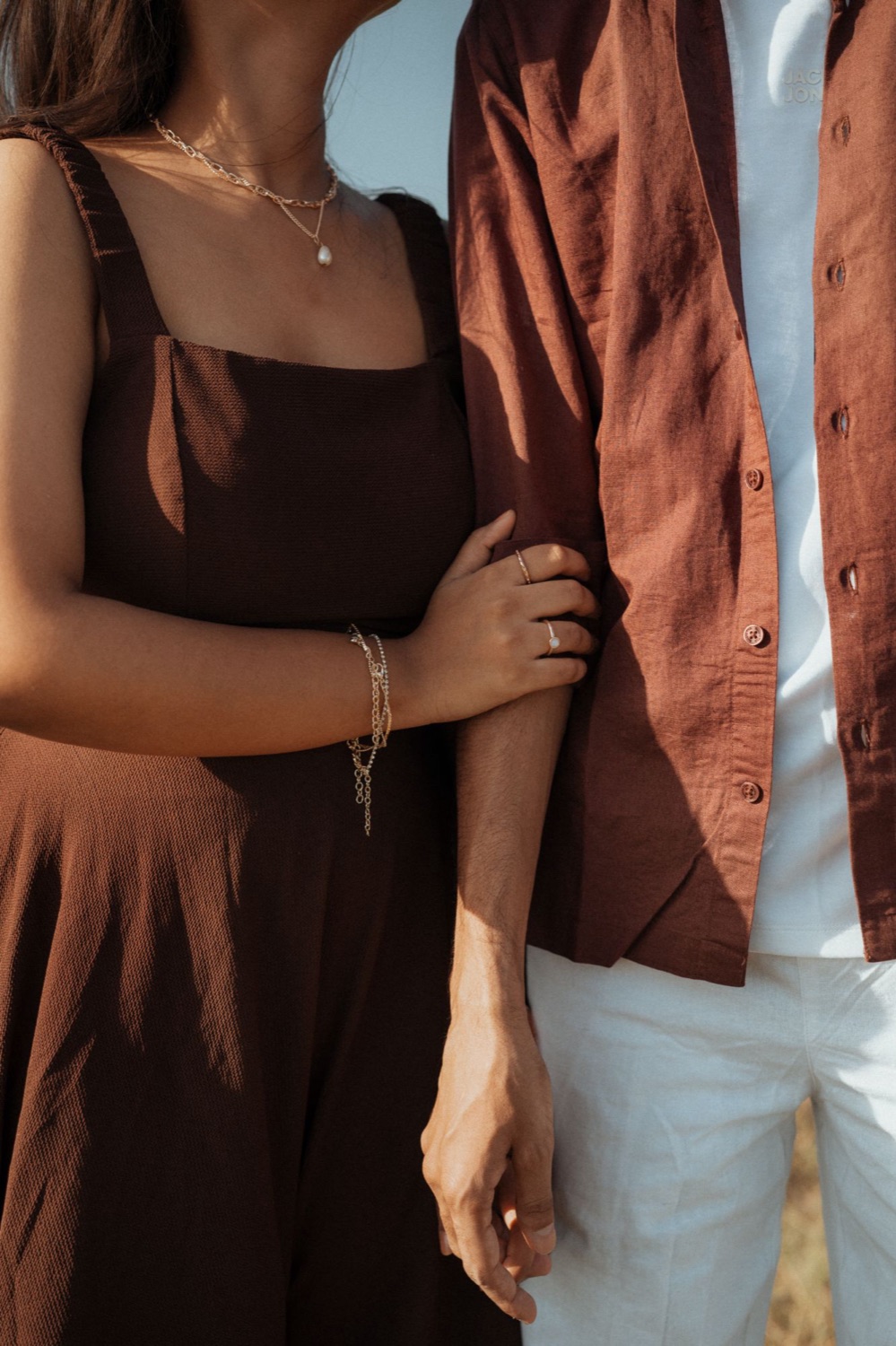 Couple in matching brown tones, arms linked