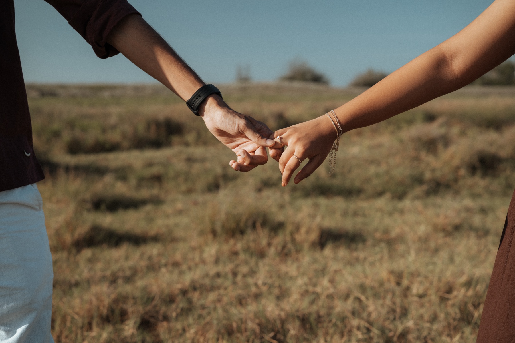 Couple holding hands in an open field