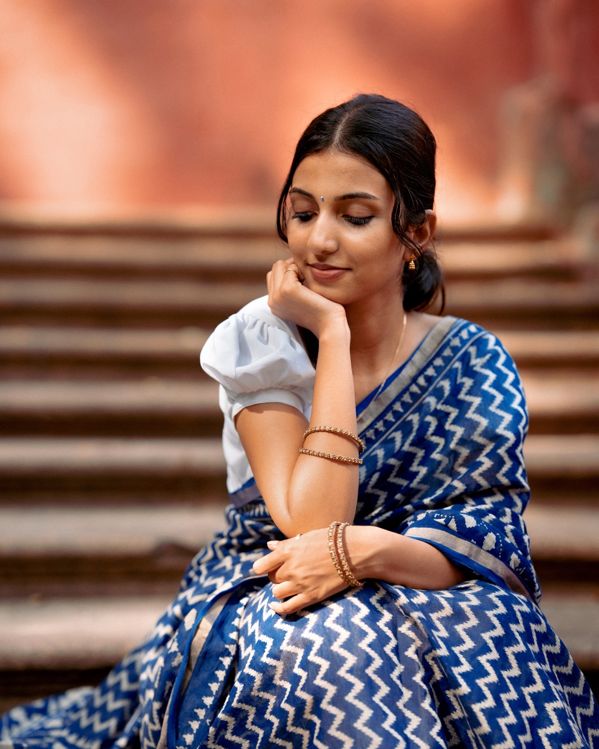 Portrait in a blue ikat saree on heritage steps