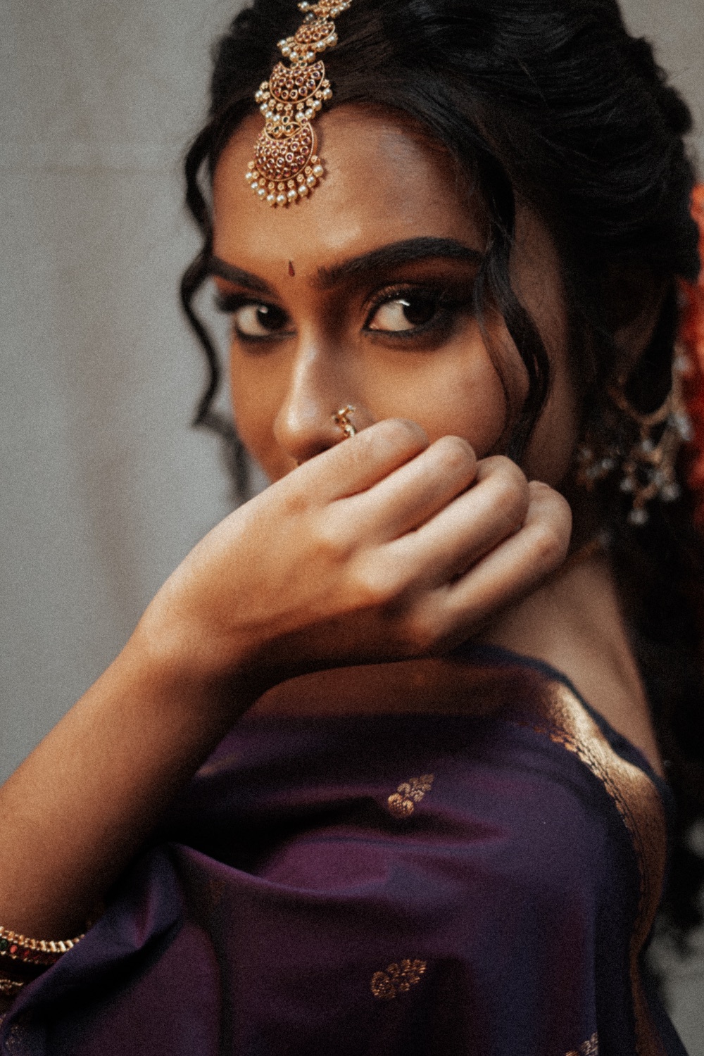 Close portrait in a purple saree and gold jewellery
