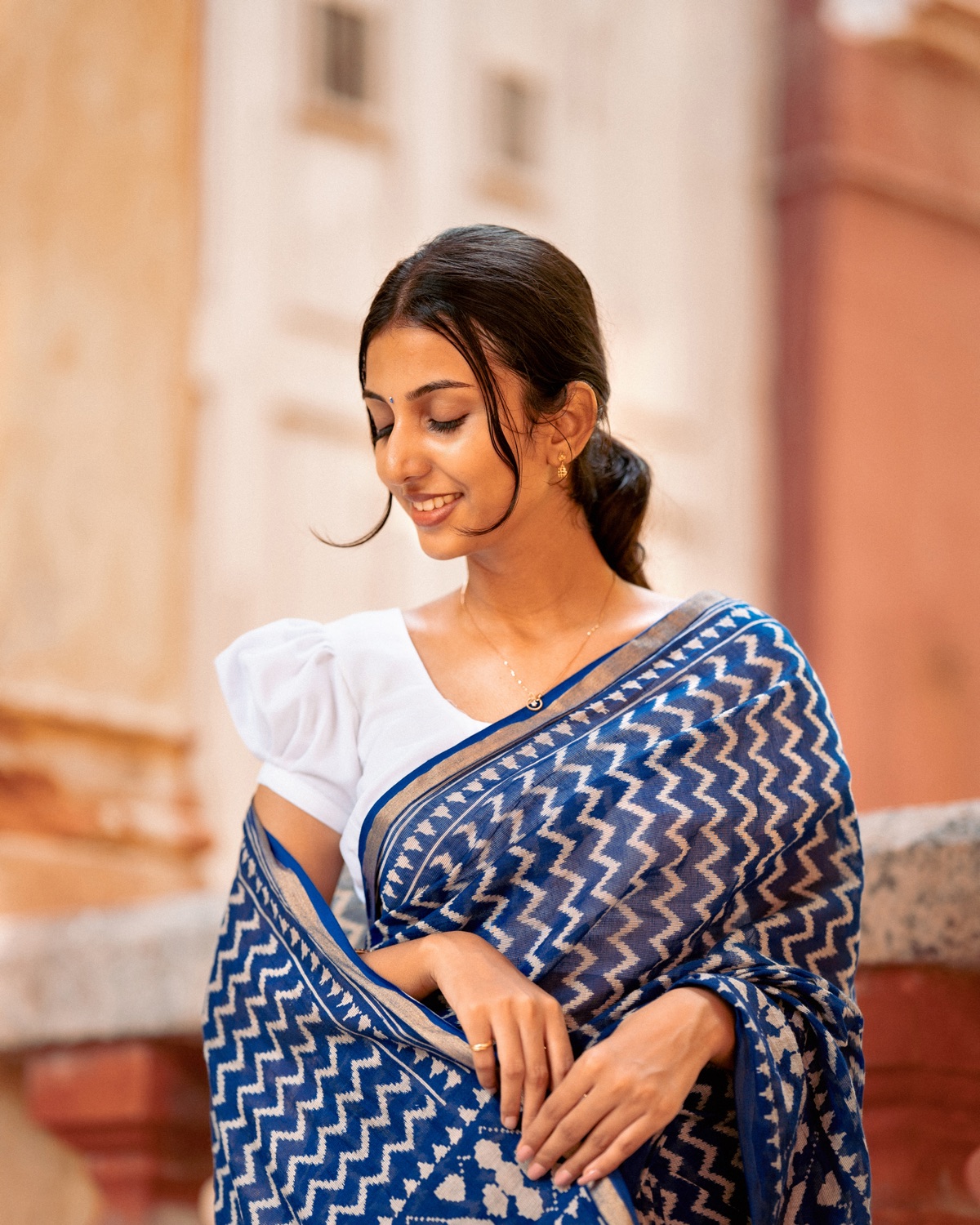 Portrait in a blue ikat saree, looking down