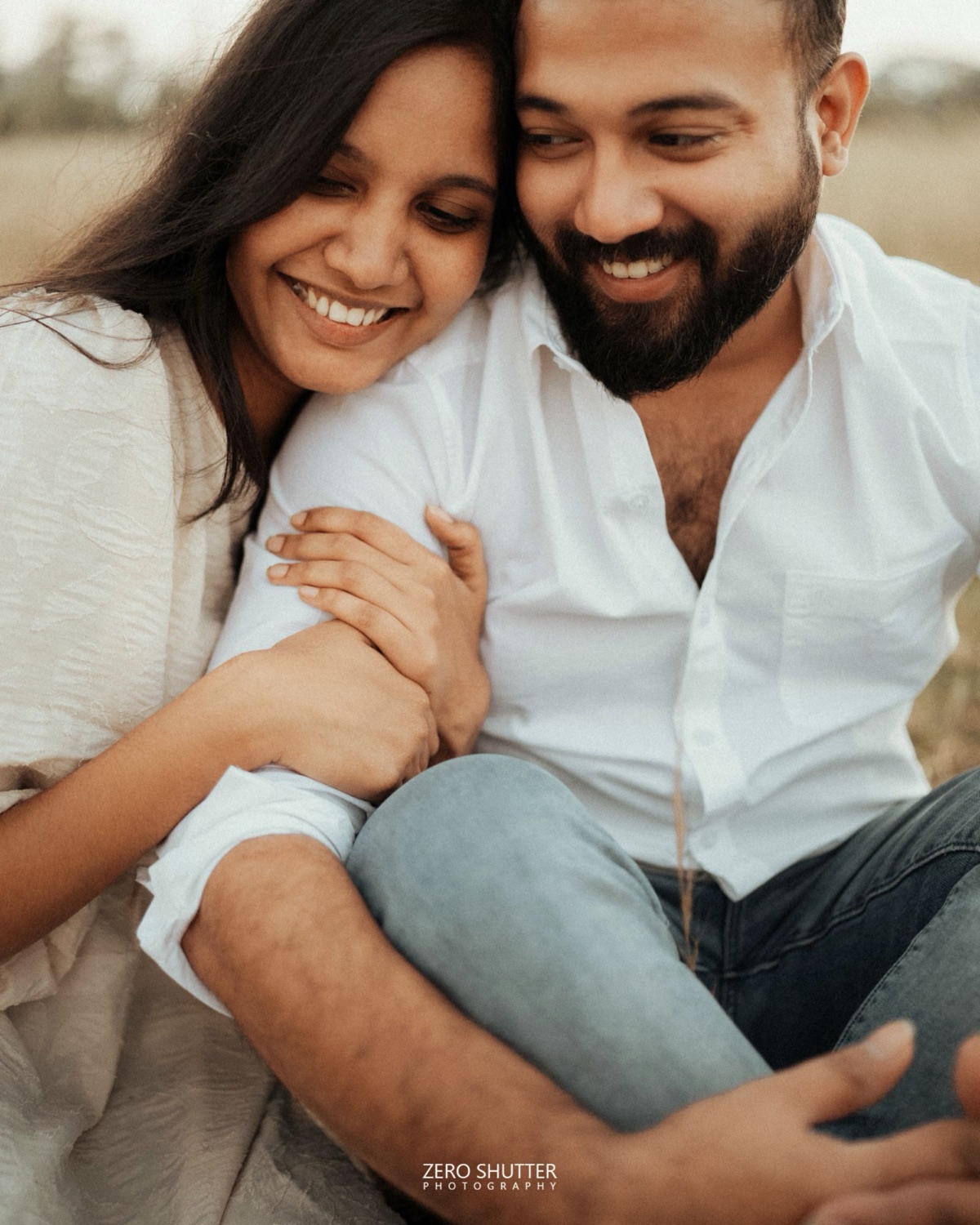 Couple laughing together, her head resting on his shoulder